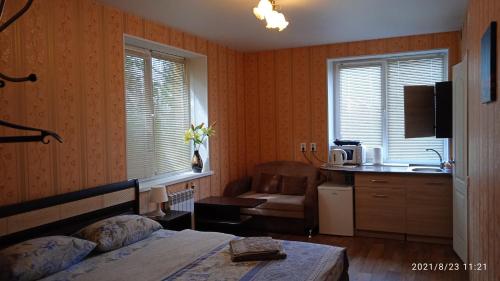 1 dormitorio con 1 cama y lavamanos y cocina en Hostel Yasen, en Perm