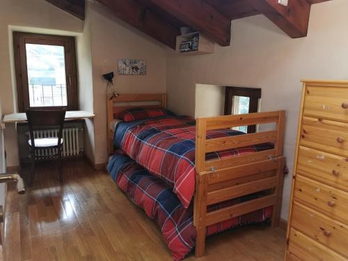 Affascinante appartamento ai piedi dell'ovovia في كورمايور: غرفة نوم بها سرير ومكتب وكرسي