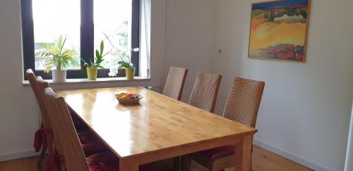 a dining room table with chairs and a bowl of fruit on it at Ferienhaus Am Heidebad in Schmelz