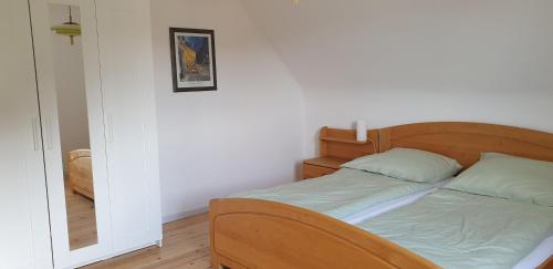 a bed with a wooden headboard in a room at Ferienhaus Am Heidebad in Schmelz