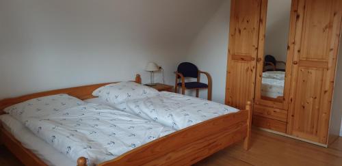 ein Schlafzimmer mit einem Bett mit einem Holzrahmen in der Unterkunft Ferienhaus Am Heidebad in Schmelz