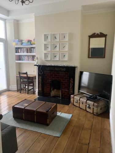 a living room with a fireplace and a flat screen tv at Beautiful Tenby House, sleeps 10, pets allowed in Tenby
