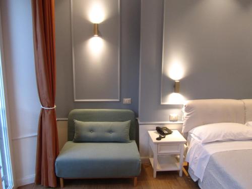 a room with a chair and a bed and a side table at Hotel Borgovico in Como