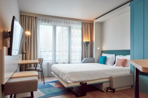 a hotel room with a bed and a desk at Aparthotel Adagio Paris Suresnes Longchamp in Suresnes