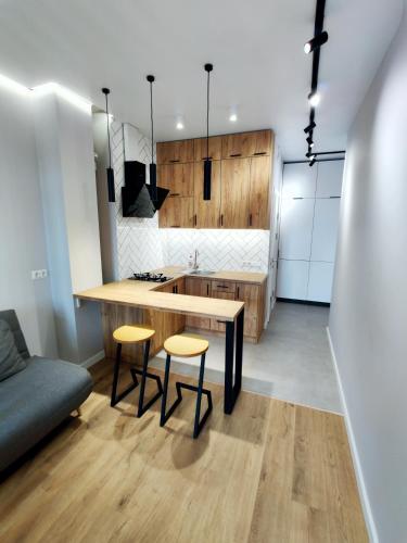 a kitchen with a wooden table and two stools at Wood Apartment in Odesa