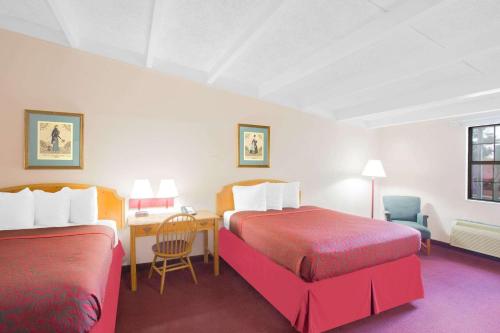 Habitación de hotel con 2 camas y escritorio en Days Inn by Wyndham Tallahassee University Center, en Tallahassee