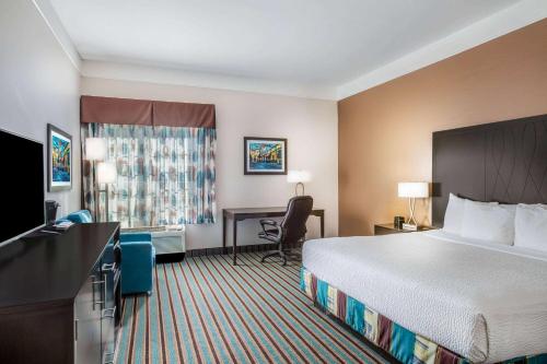 una camera d'albergo con un grande letto e una scrivania di La Quinta by Wyndham Bakersfield North a Bakersfield