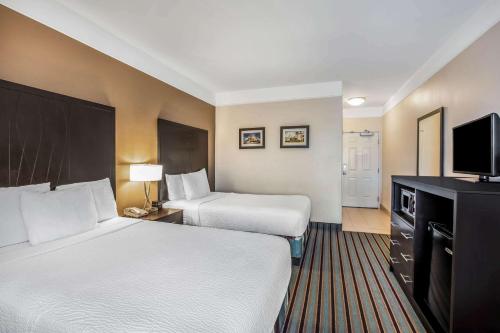 a hotel room with two beds and a television at La Quinta by Wyndham Bakersfield North in Bakersfield