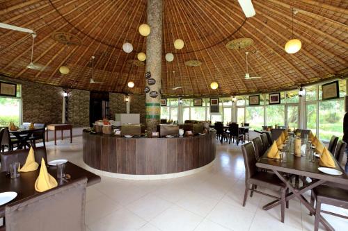 a restaurant with tables and chairs and a bar at Click Resort Corbett Tiger Den in Rāmnagar