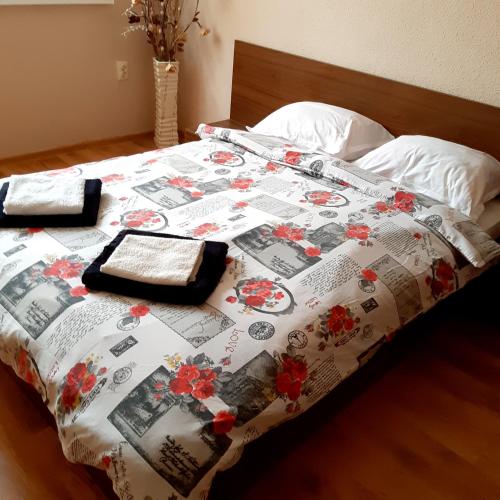 a bed with a quilt on top of it at Апартамент "Рая" in Dobrich