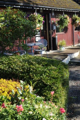 um jardim com mesa, cadeiras e flores em Roam West em Fort William