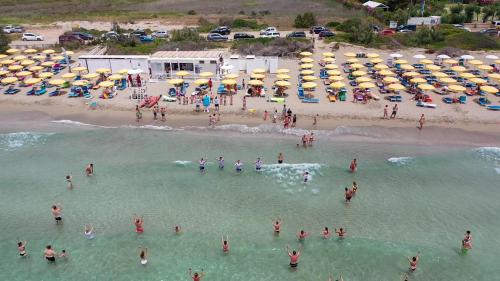 a group of people in the water at a beach at Nicolaus Club La Giurlita in Ugento