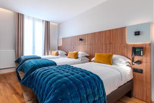 A bed or beds in a room at Hôtel de Bellevue Paris Gare du Nord