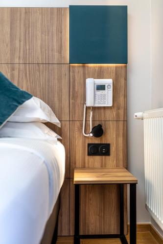 a bedroom with a bed and a telephone on a wall at Hôtel de Bellevue Paris Gare du Nord in Paris