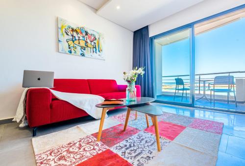 a living room with a red couch and a table at Asilah 32 in Asilah
