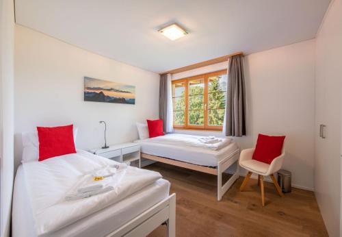 een slaapkamer met twee bedden en een raam bij Panoramapark Soleil Chalet A in Wengen
