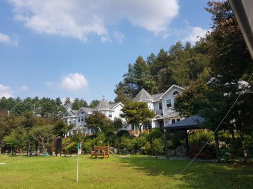 a group of houses in a yard with a kite at Tomato Pension in Hongcheon