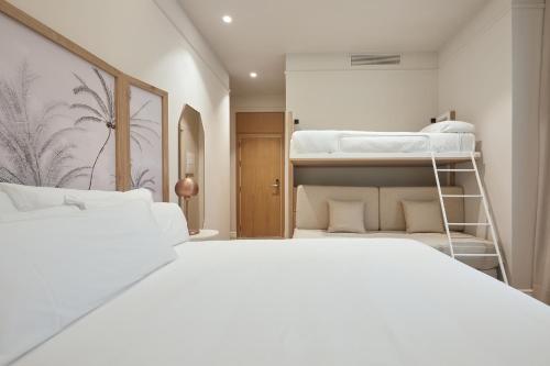 a bedroom with two bunk beds with white sheets at ICON Malabar in Málaga