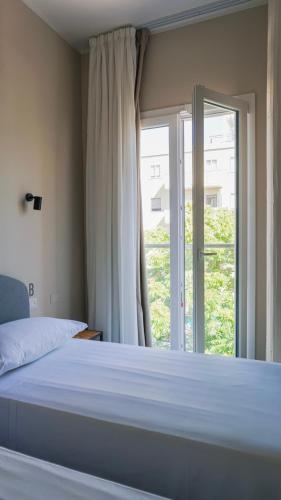 a bedroom with a bed and a large window at Piccolo Catalunya Hostel in Alghero