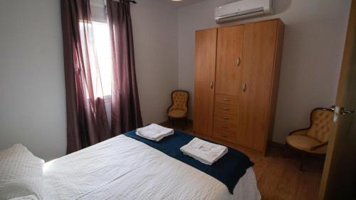 a bedroom with a bed with two towels on it at Apartamento/Casa El Puente in Toledo
