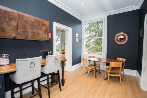 a dining room with blue walls and a table and chairs at Torrington Hall in St. Albans