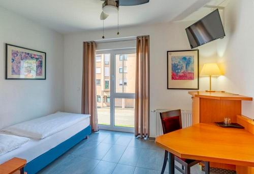 a bedroom with a bed and a desk and a table at Heilbronner Hotel am schönen Theater in Heilbronn