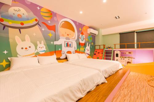 two beds in a childrens bedroom with a space themed wall at 閣樂親子旅宿Kids Fun Hotel in Luodong