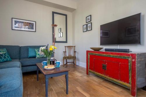 a living room with a couch and a tv and a table at Spencer House in York