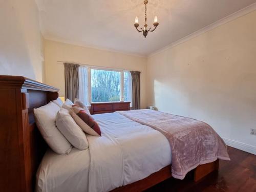 a bedroom with a bed with pillows and a window at Country Garden Oasis with Parking and Wi-Fi in Taupaki