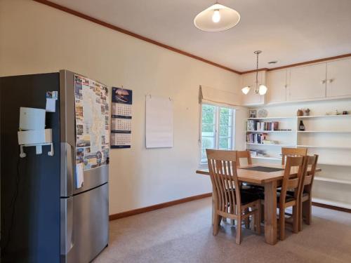 a kitchen with a table and a refrigerator at Country Garden Oasis with Parking and Wi-Fi in Taupaki