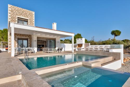 a swimming pool in the backyard of a house at Villa AmberBlue Pefkos in Pefki