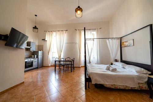a bedroom with a bed and a kitchen with a table at Casa Vacanze Naxos in Lido di Ostia