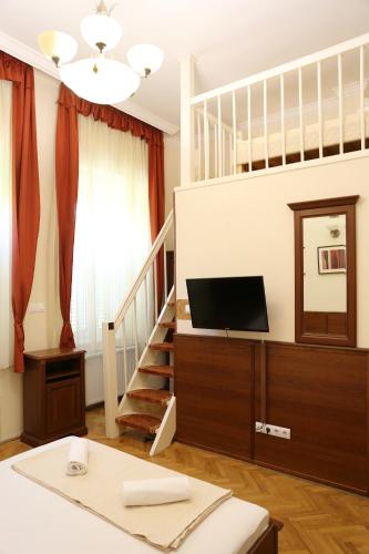 a living room with a staircase with a television at Péterfia Panzió in Debrecen
