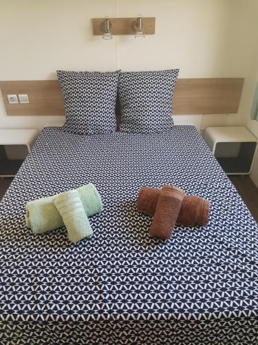 a bed with three pillows on top of it at Frejus tout confort, maxi 420 m des piscines, climatisation,plus ventilation toutes les chambres, linge de lit et de toilette , coffre fort, lavé vaisselle machine à laver grande terrasse couverte velos et wifi possible in Fréjus