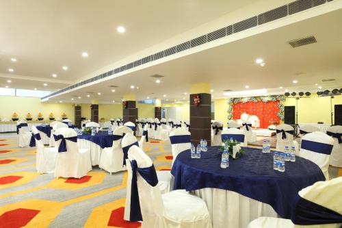une salle de banquet avec des tables et des chaises bleues et blanches dans l'établissement Click Hotel Transport Nagar, à Lucknow