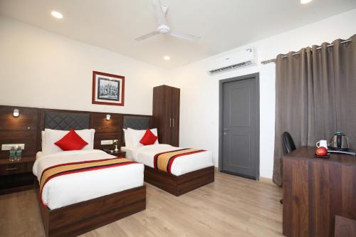 a hotel room with two beds and a television at Click Hotel Transport Nagar in Lucknow