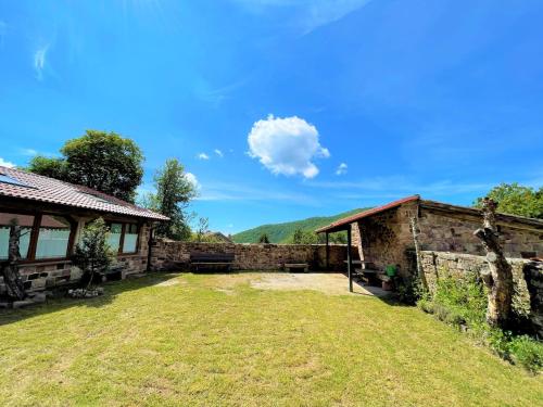 una casa con una pared de piedra y un patio en El Rincón de Golobar en Brañosera, en Brañosera