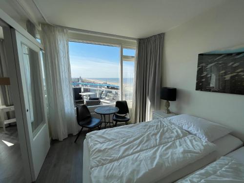 a bedroom with a bed and a view of the ocean at Droomvakanties Egmond Zeezicht in Egmond aan Zee