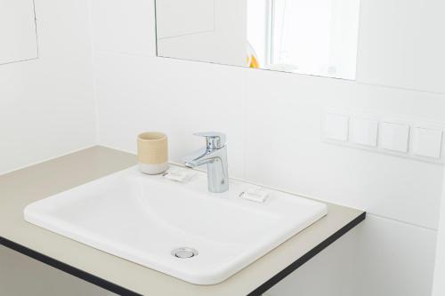 a white sink in a bathroom with a mirror at Micro Rooftop Penzing in Vienna