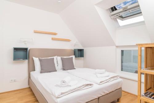 - une chambre avec un lit doté de draps blancs et une fenêtre dans l'établissement Micro Rooftop Penzing, à Vienne