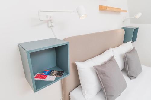 a blue cabinet above a bed with pillows at Micro Rooftop Penzing in Vienna