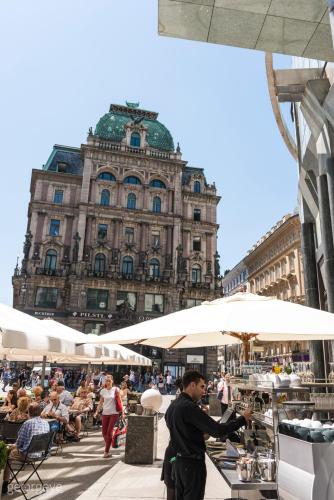 a man in a suit standing in front of a building at Micro Rooftop Penzing in Vienna