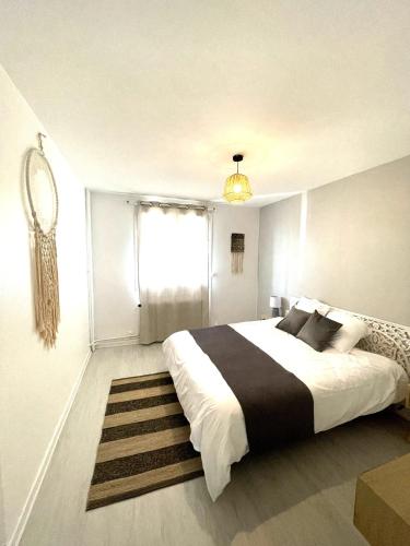 une chambre avec un grand lit et une fenêtre dans l'établissement Le Châteaucreux - Cosy & SPA, à Saint-Étienne