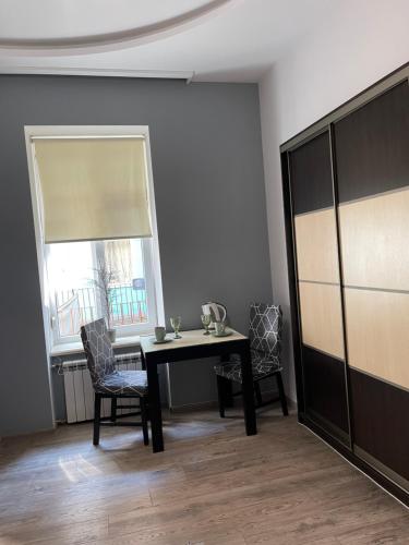a dining room with a table and chairs and a window at Apartment near Opera in Lviv