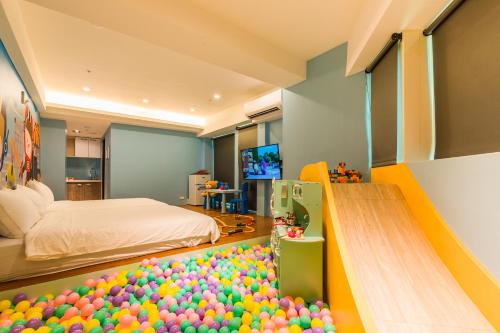 a room with a bed and a bunch of balls on the floor at 閣樂親子旅宿Kids Fun Hotel in Luodong