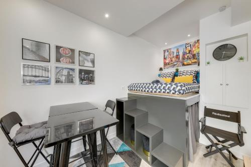 Cette chambre comprend un lit, un bureau et des chaises. dans l'établissement Aux portes de Bordeaux L'Actors Studio MindUrGuest, à Lormont