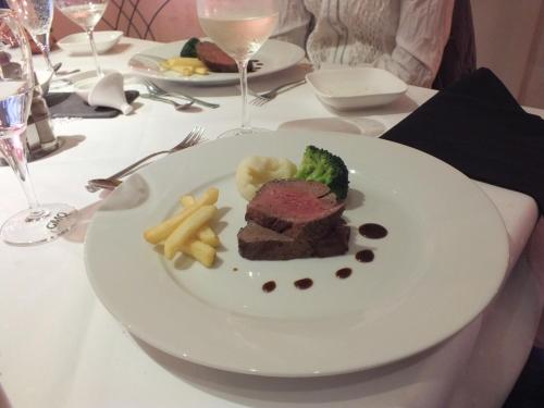 a plate of steak and french fries on a table at Rezas Restaurant Gästehaus in Oberbillig