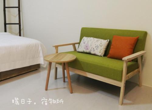 a green couch and a table in a room at 曬日子宿物所Sundays BnB 包棟民宿 in Huxi