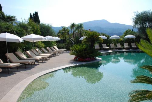 - une piscine avec des chaises longues et des parasols dans un complexe dans l'établissement Domaine De Respelido, à Carros