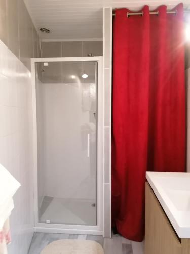 a bathroom with a shower with a red shower curtain at En Provence à MOLLANS in Mollans-sur-Ouvèze